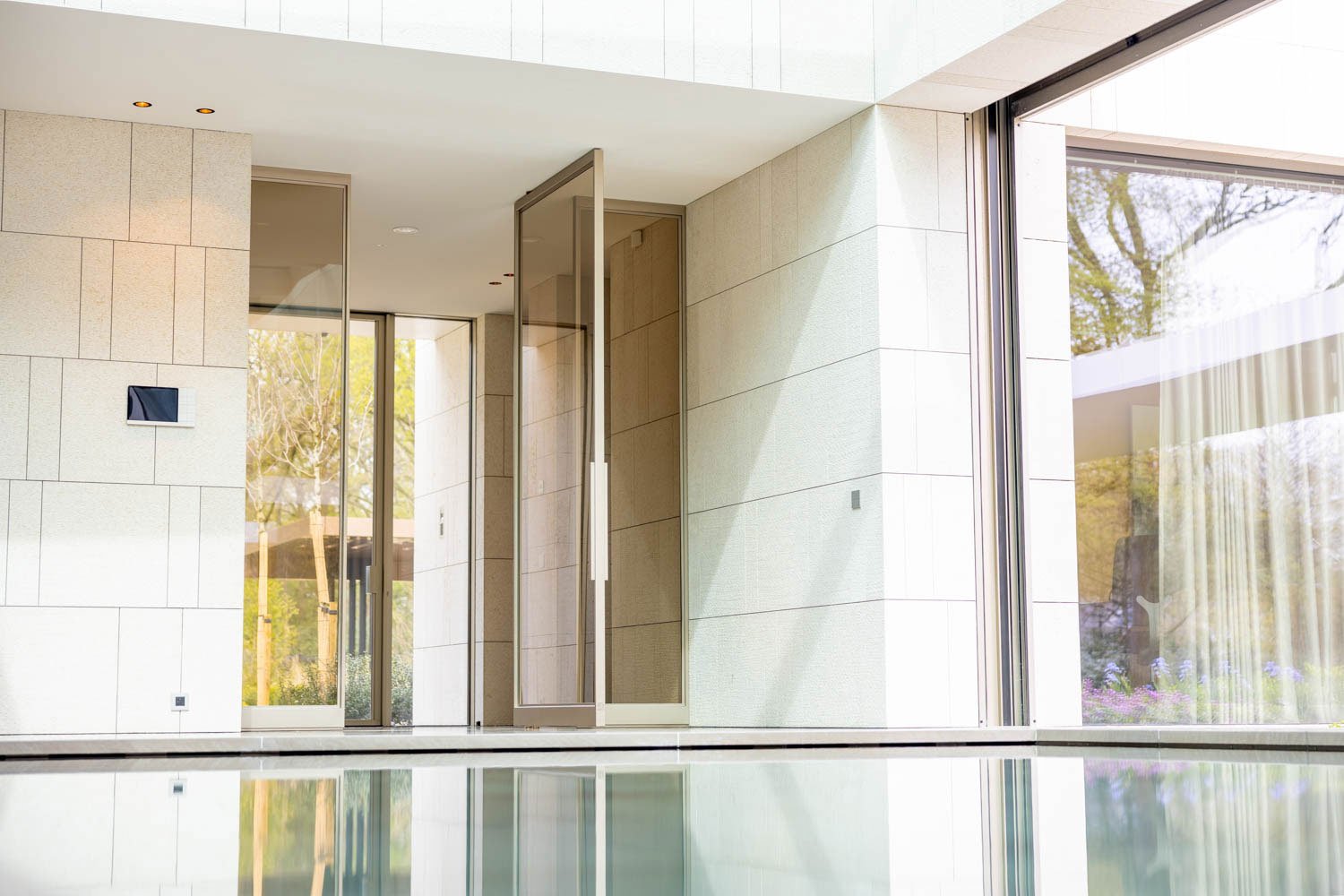 a steel pivot door leading to an indoor swimming pool