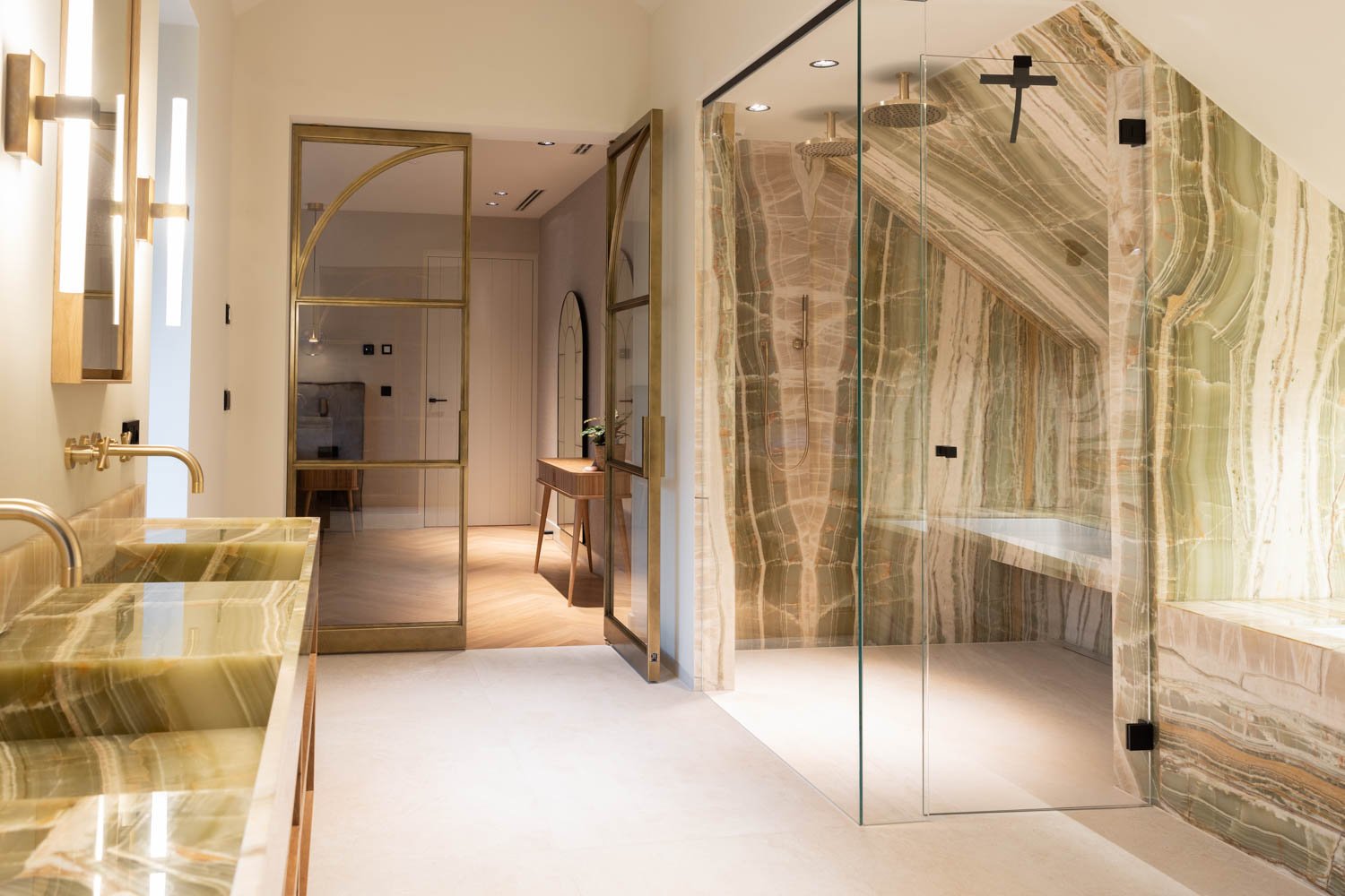 steel glazed door in a brass finish in a luxury bathroom design